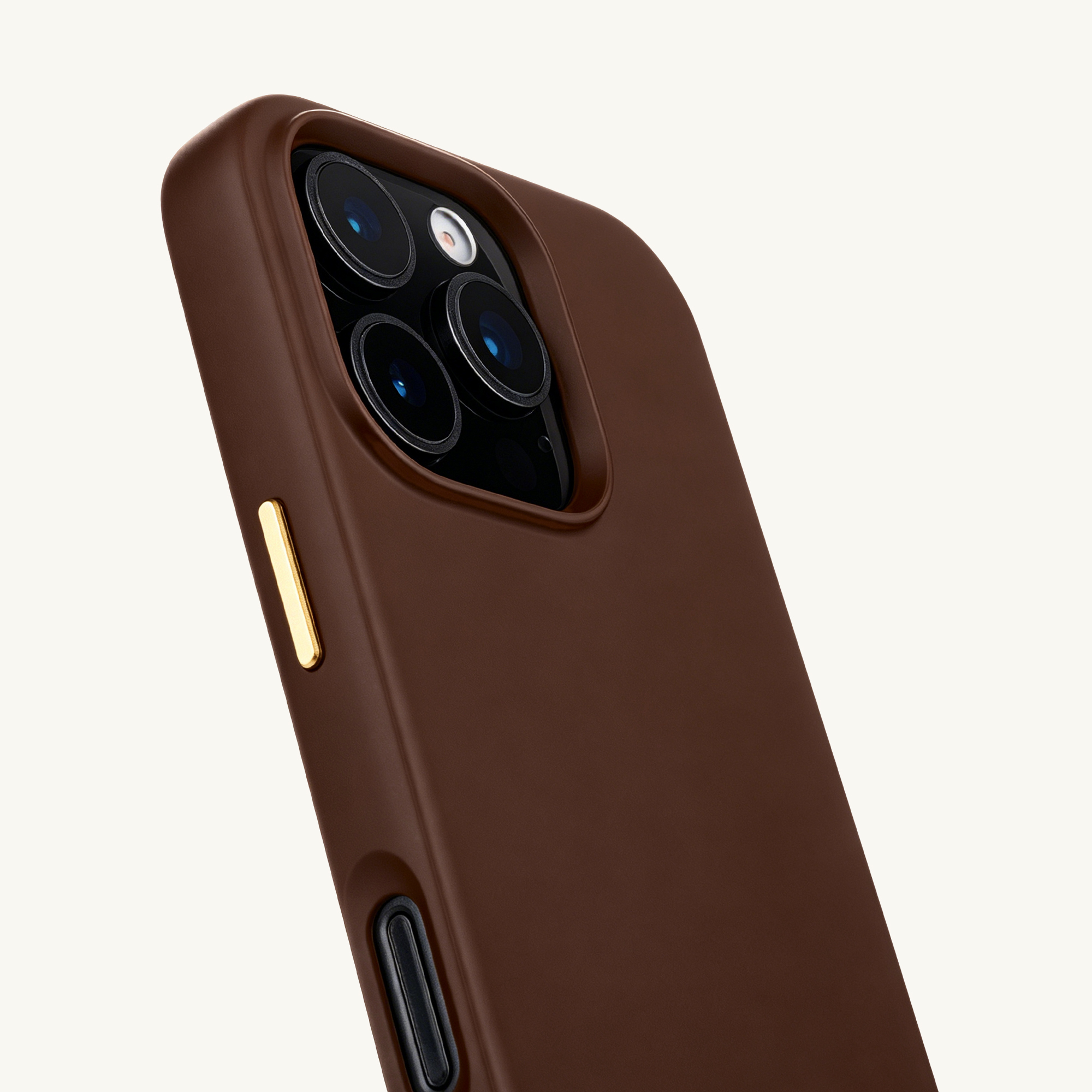 Primer plano de una funda de teléfono marrón con módulo de cámara y botón dorado.