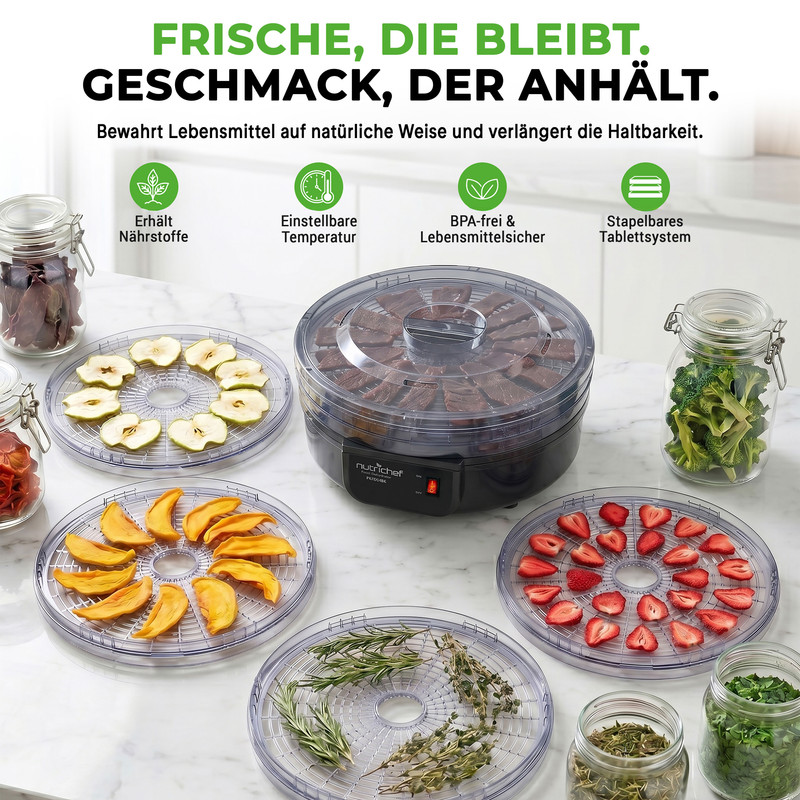 Ein Dörrgerät mit verschiedenen Früchten, Gemüse und Kräutern auf Tabletts.
