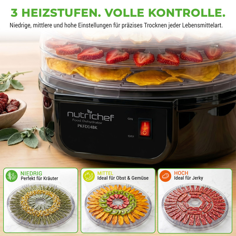 Ein schwarzer Dörrautomat mit drei Ebenen, gefüllt mit Erdbeeren, Mango und Kräutern.