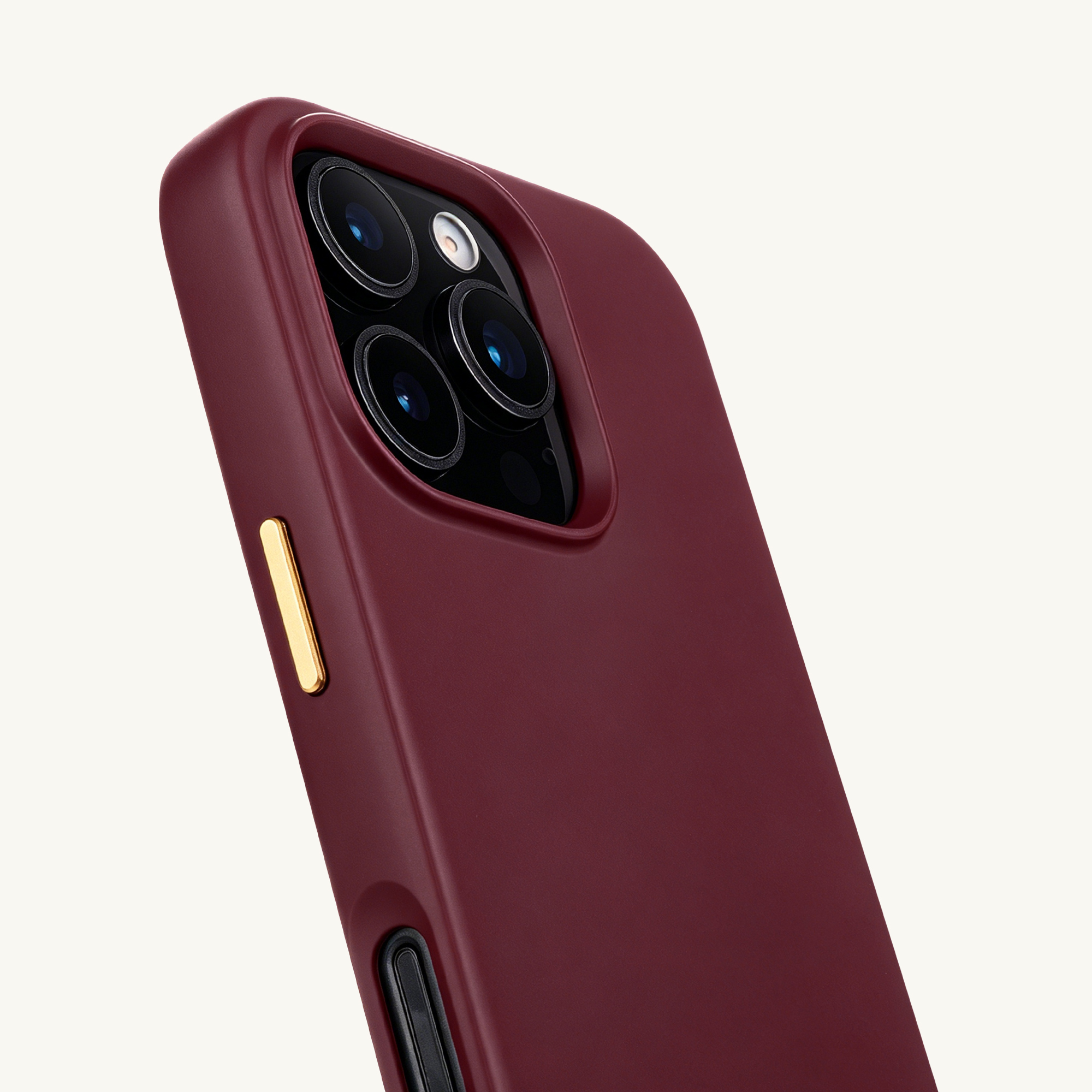 Funda de teléfono roja oscura con cuatro cámaras y botón dorado.