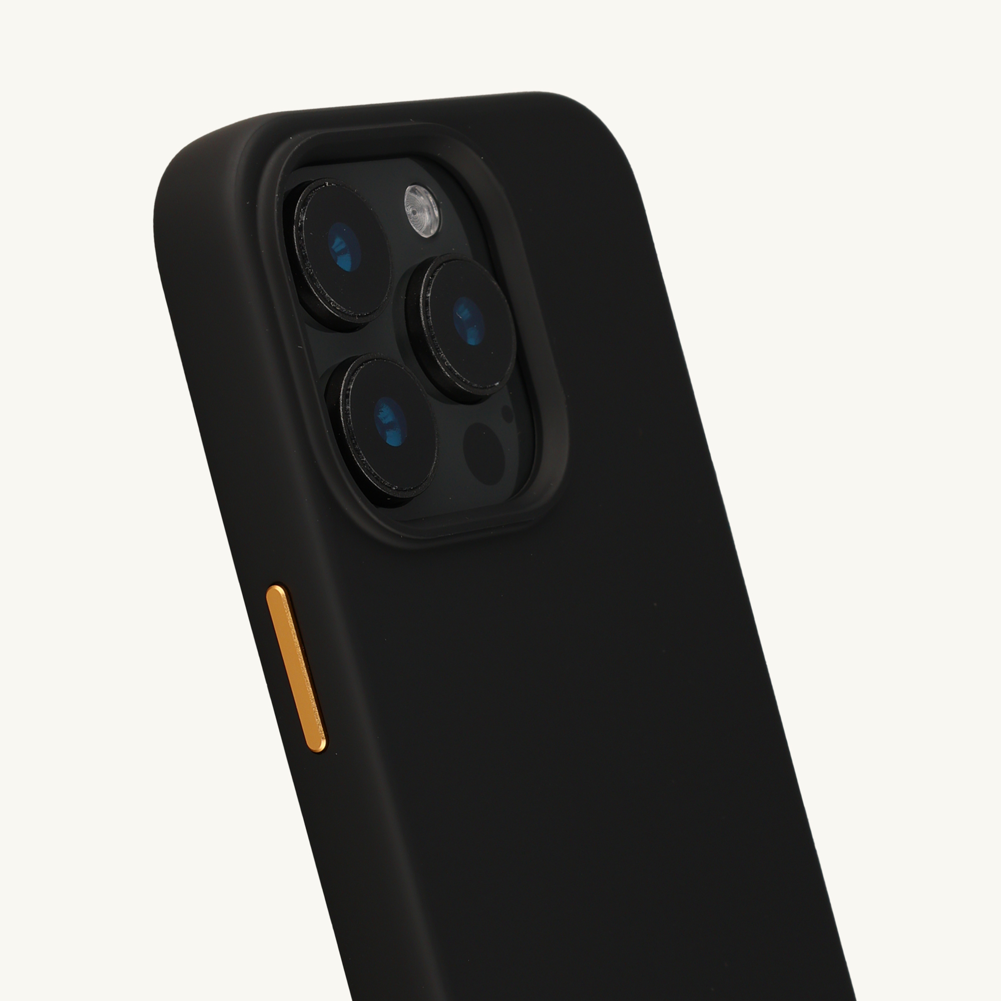 Coque de téléphone noire avec trois caméras et un bouton doré.
