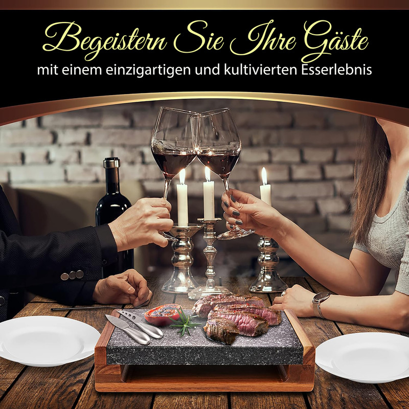 Zwei Personen stoßen mit Rotwein an, vor ihnen ein Stein mit gegrilltem Fleisch und Kerzen.
