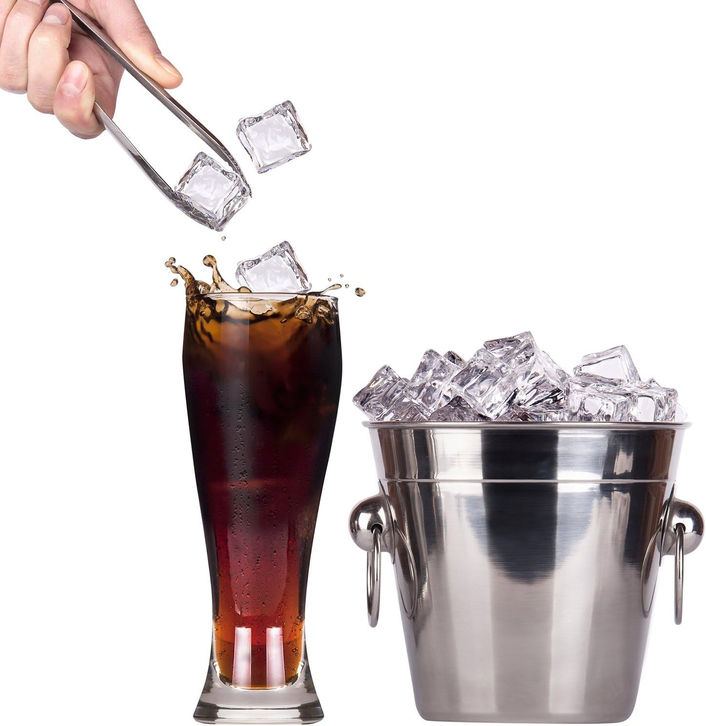 Eiswürfel fallen in ein Glas Cola neben einem Eiseimer.