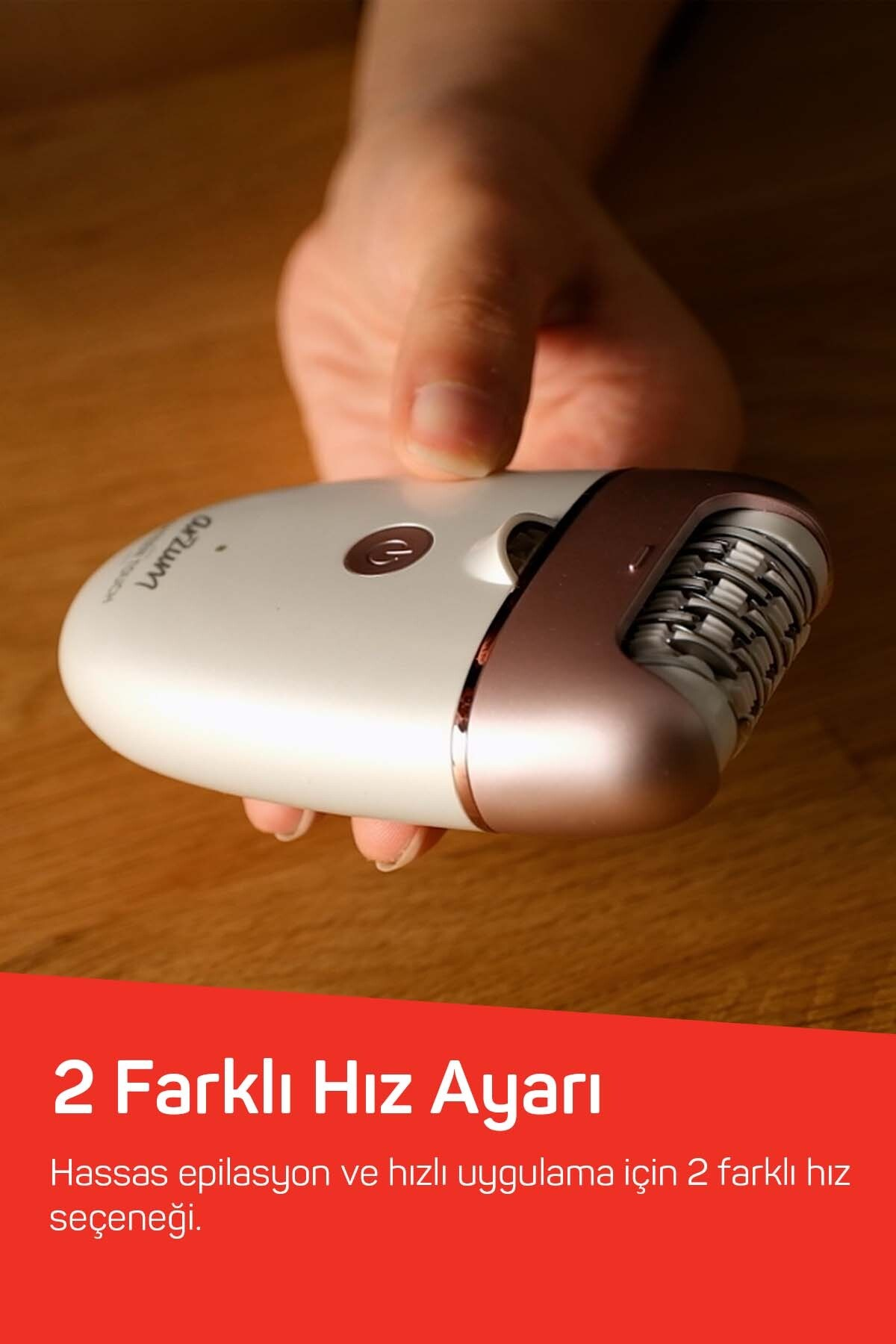 Bir el, gül altın rengi vurgulara ve kırmızı banda sahip beyaz bir epilatör tutuyor.