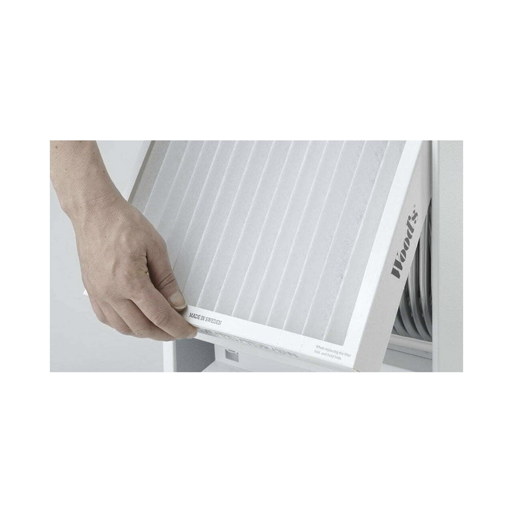 Una mano tiene un filtro dell'aria bianco plissettato, etichettato Wood's.