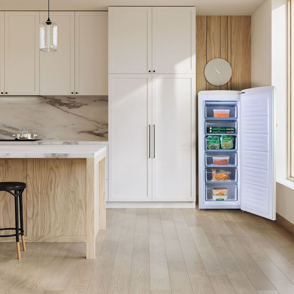 Cuisine moderne avec congélateur ouvert rempli d'aliments.