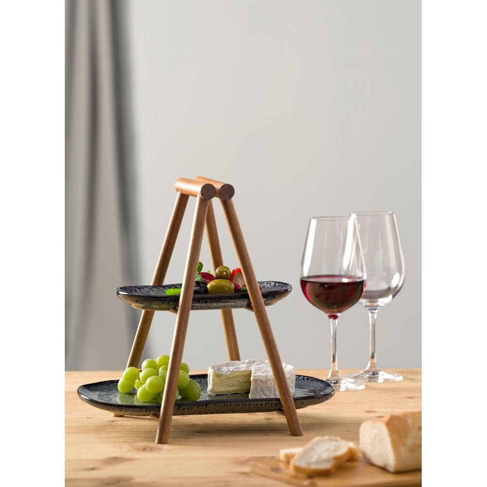 Zweistöckiger Servierteller mit Holzgestell, Käse, Trauben und Oliven.