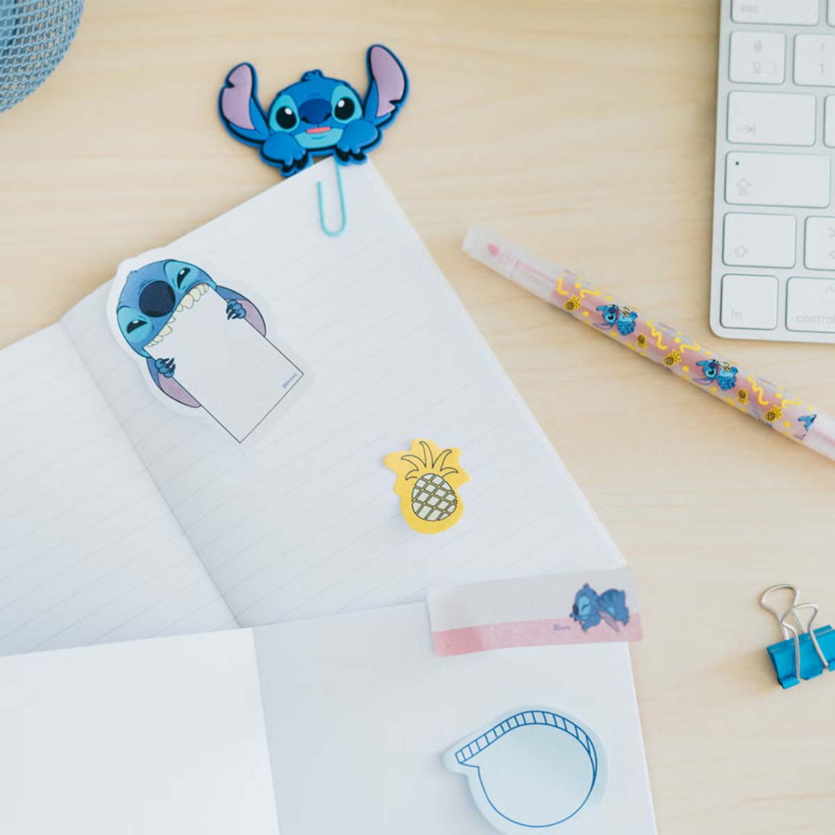 Ein Notizbuch mit Stitch-Aufklebern, einem Stift und einer Tastatur.