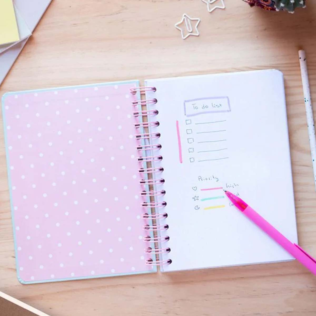 Ein offenes Notizbuch mit einer To-Do-Liste und farbigen Prioritätsmarkierungen.