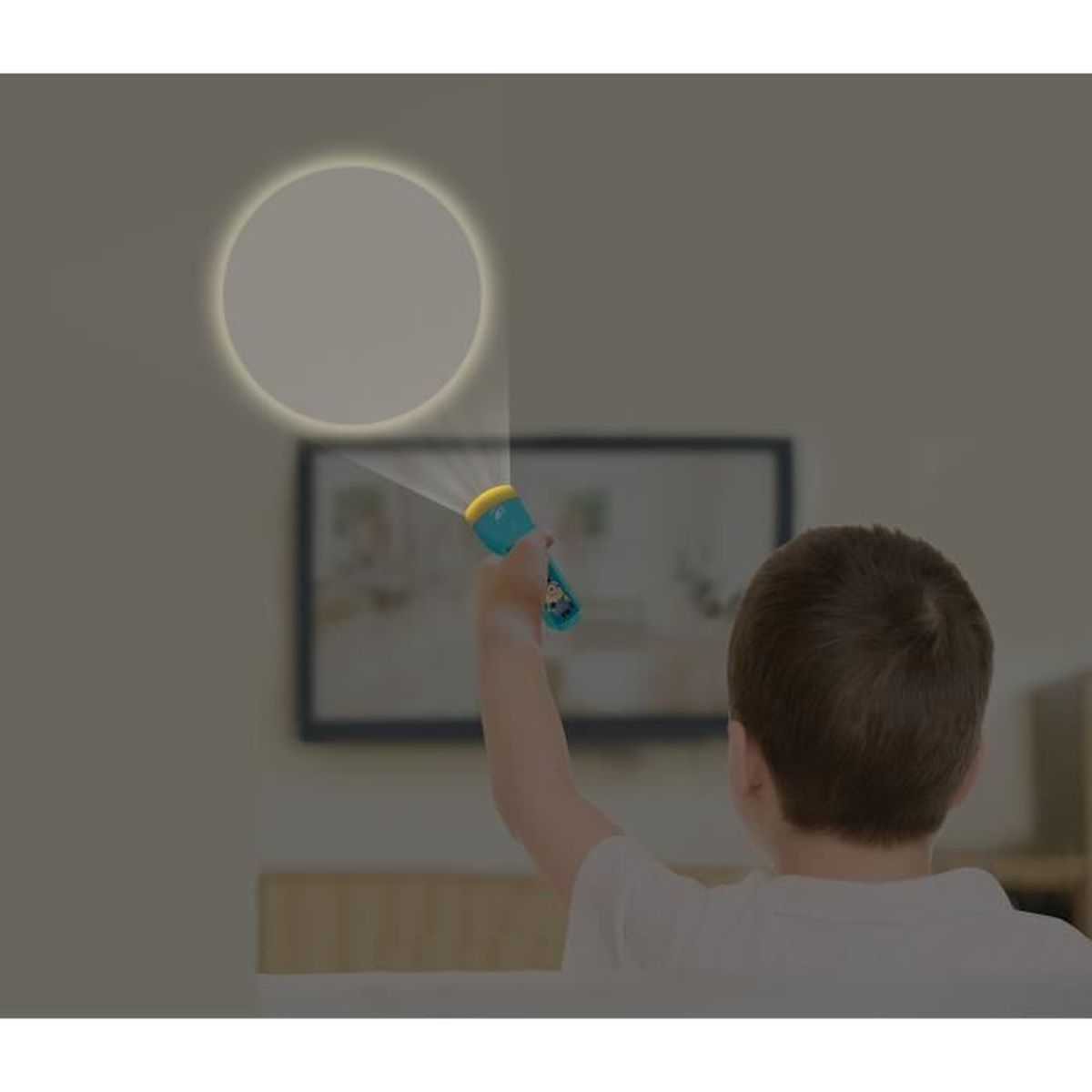 Un bambino illumina un muro con una torcia blu, creando un cerchio di luce.
