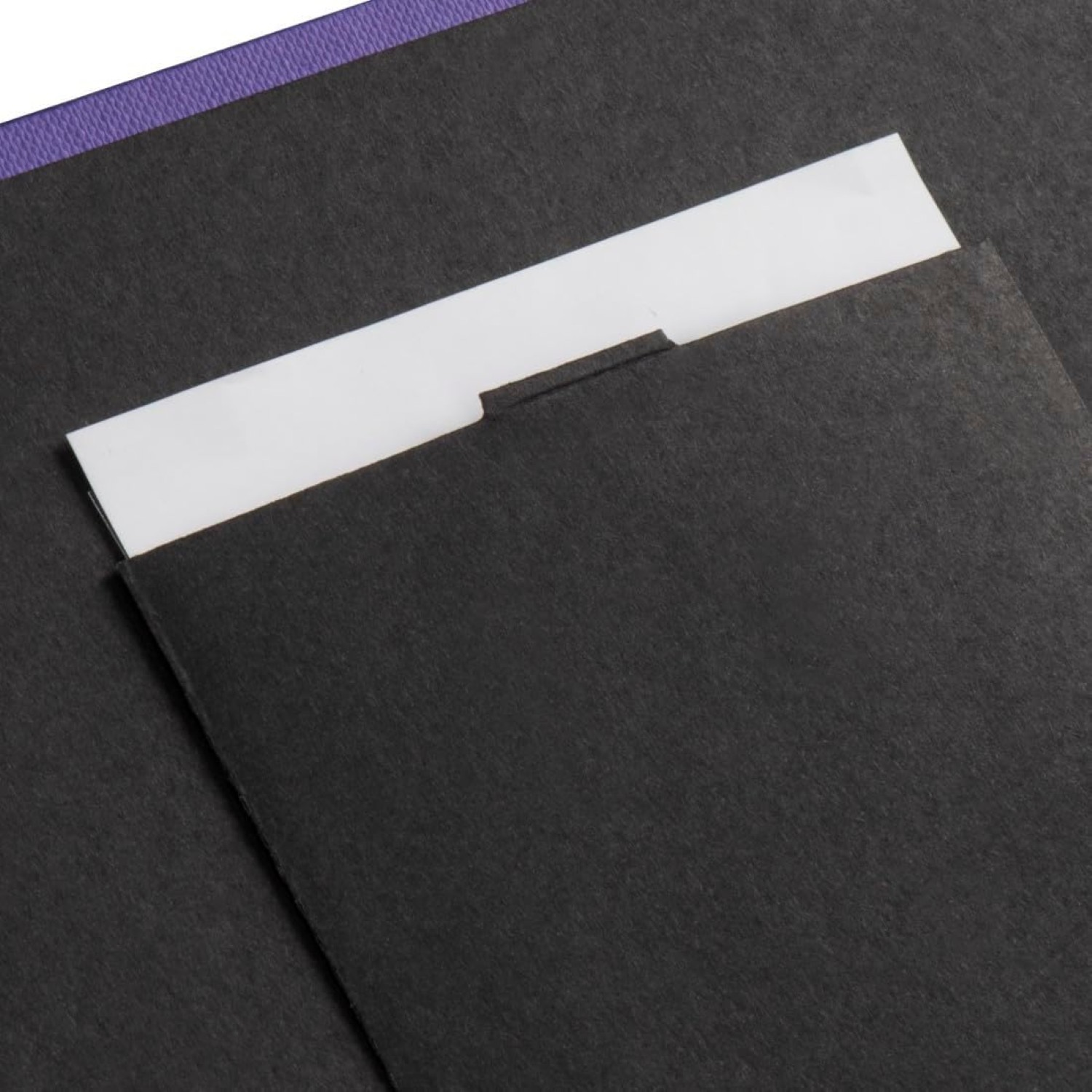 Schwarzes strukturiertes Papier mit einer weißen Lasche, die aus einer Tasche lugt. Lila Rand oben.