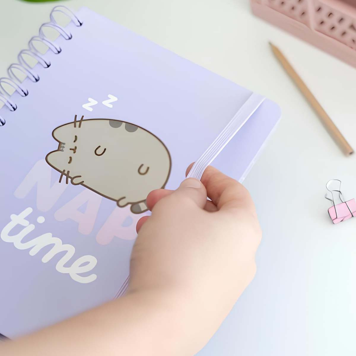 Ein lila Notizbuch mit einer schlafenden Katze und dem Text "Nap time".