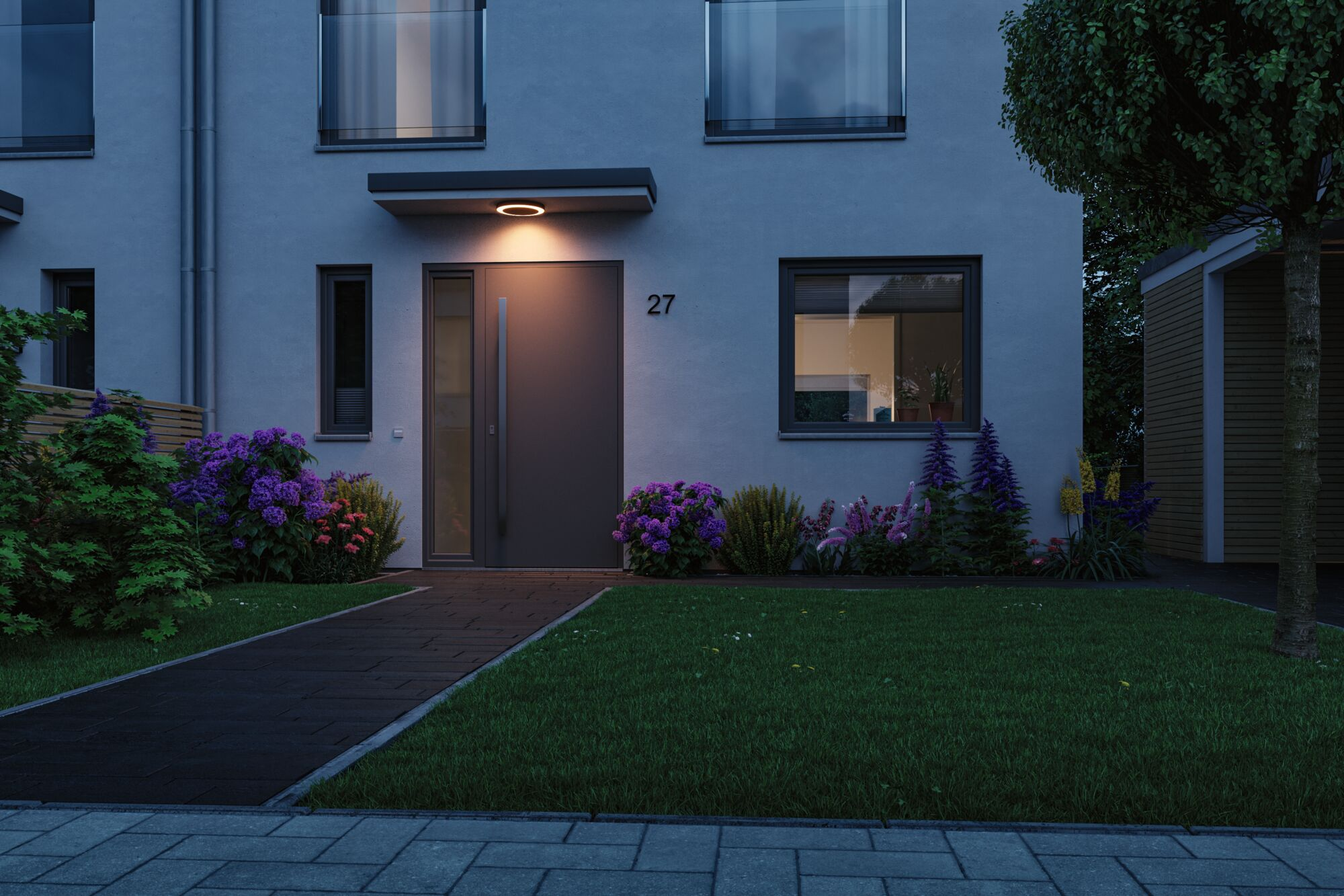 Ein modernes Haus mit Eingangstür, Fenster und Blumen vor dem Rasen.