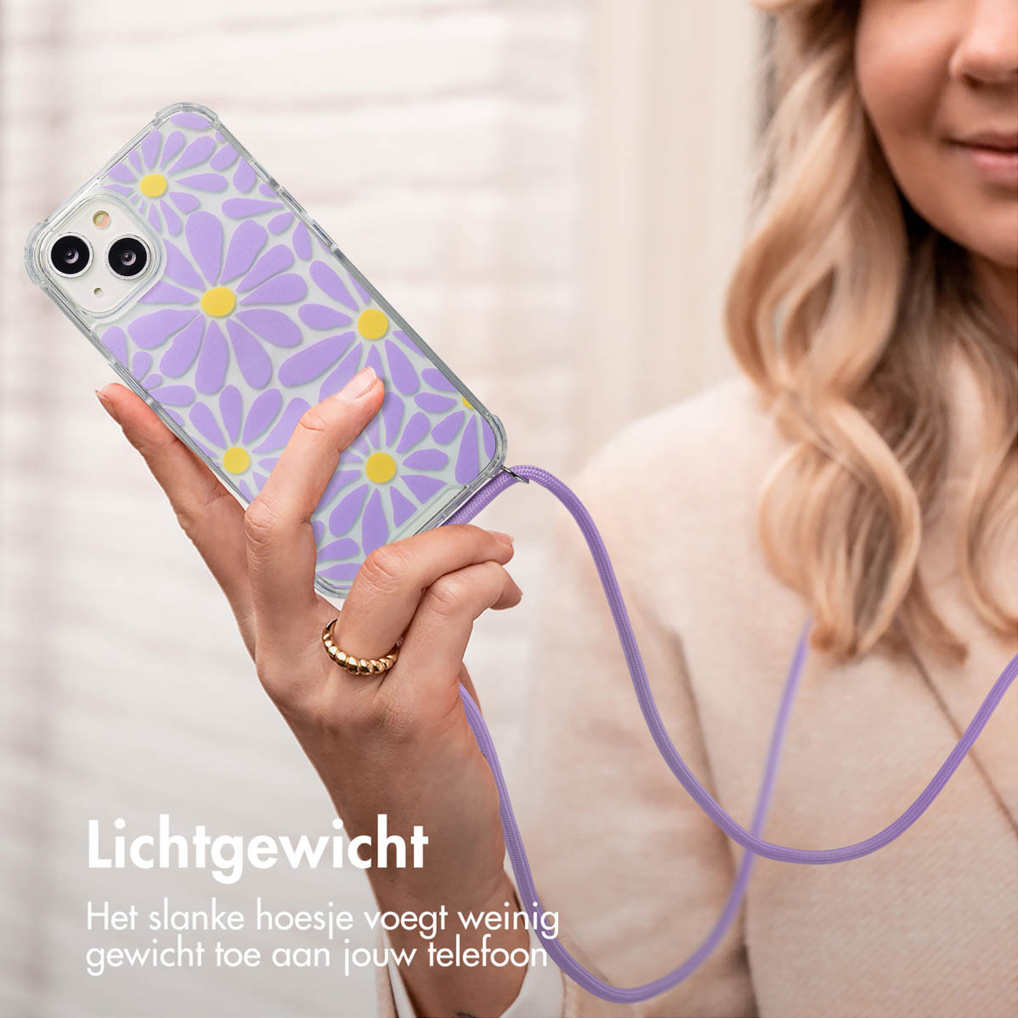 Une main tient une coque de téléphone à motif floral violet avec un centre jaune.