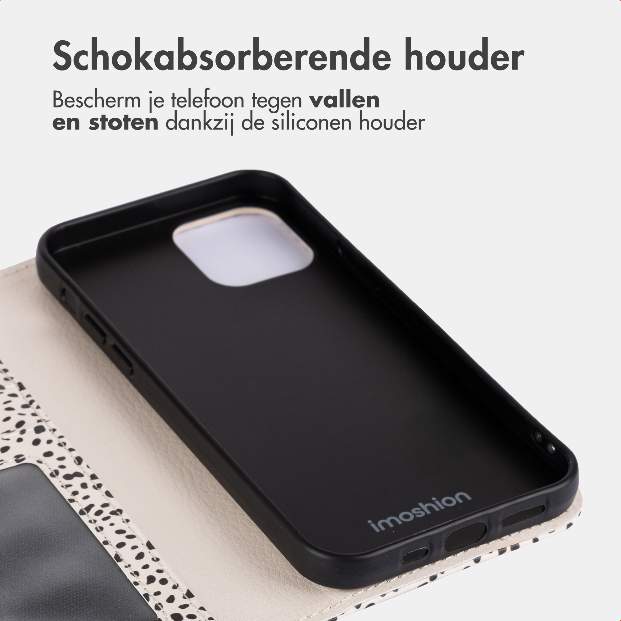 Schwarze Handyhülle mit Fleckenmuster, auf einer hellen Oberfläche liegend.