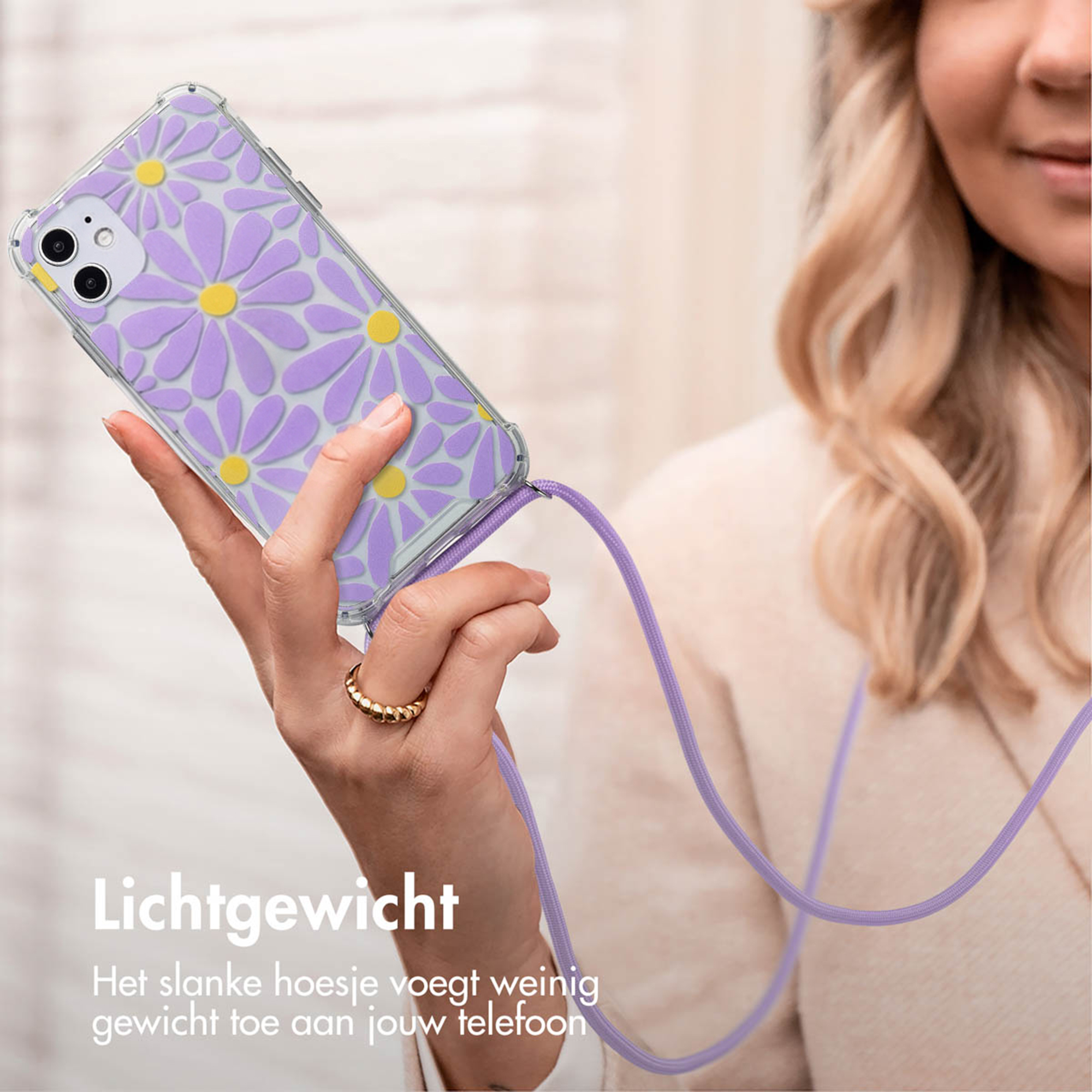 Una donna tiene una custodia per telefono con margherite viola e un cordino.