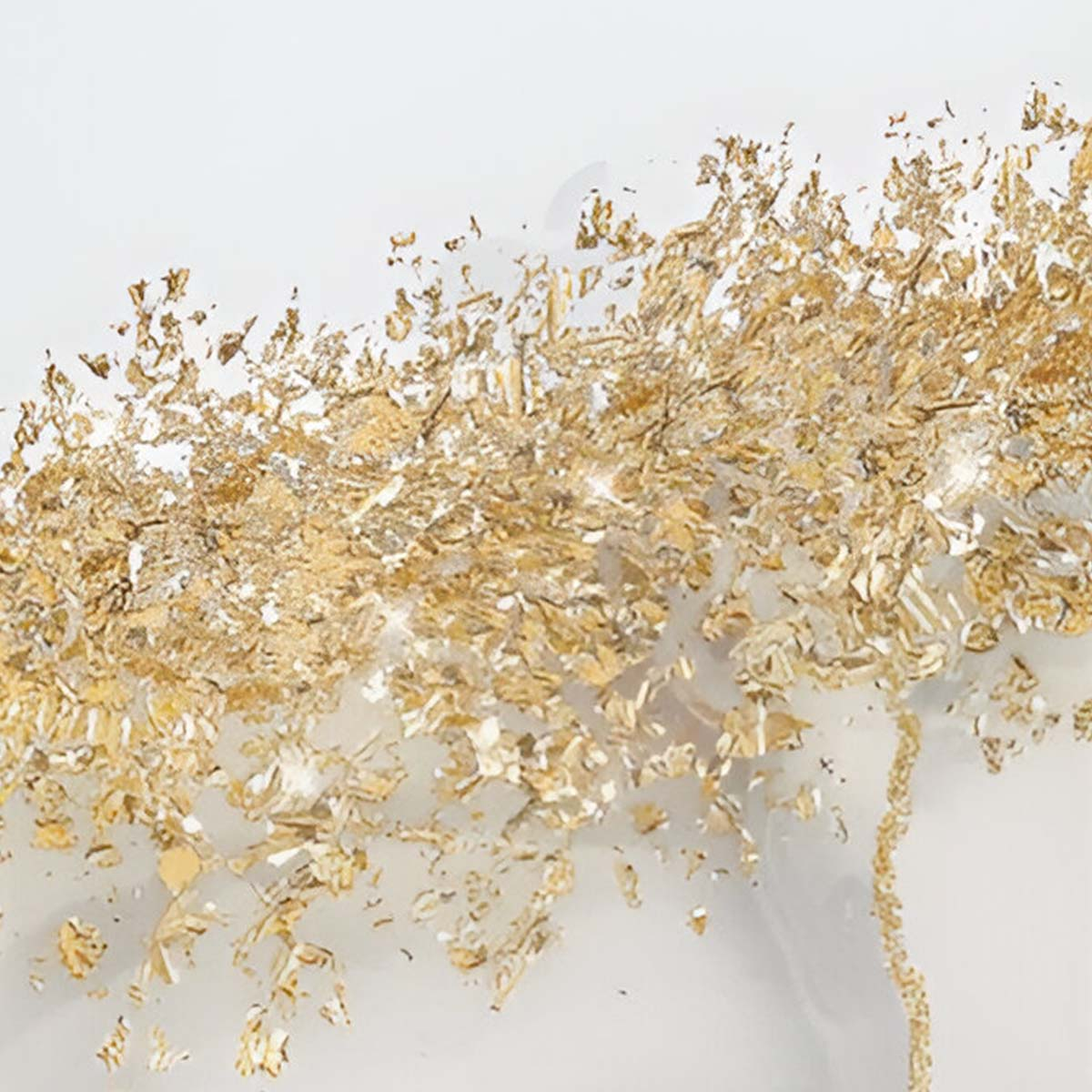 Frammenti di foglia d'oro sparsi su uno sfondo bianco.