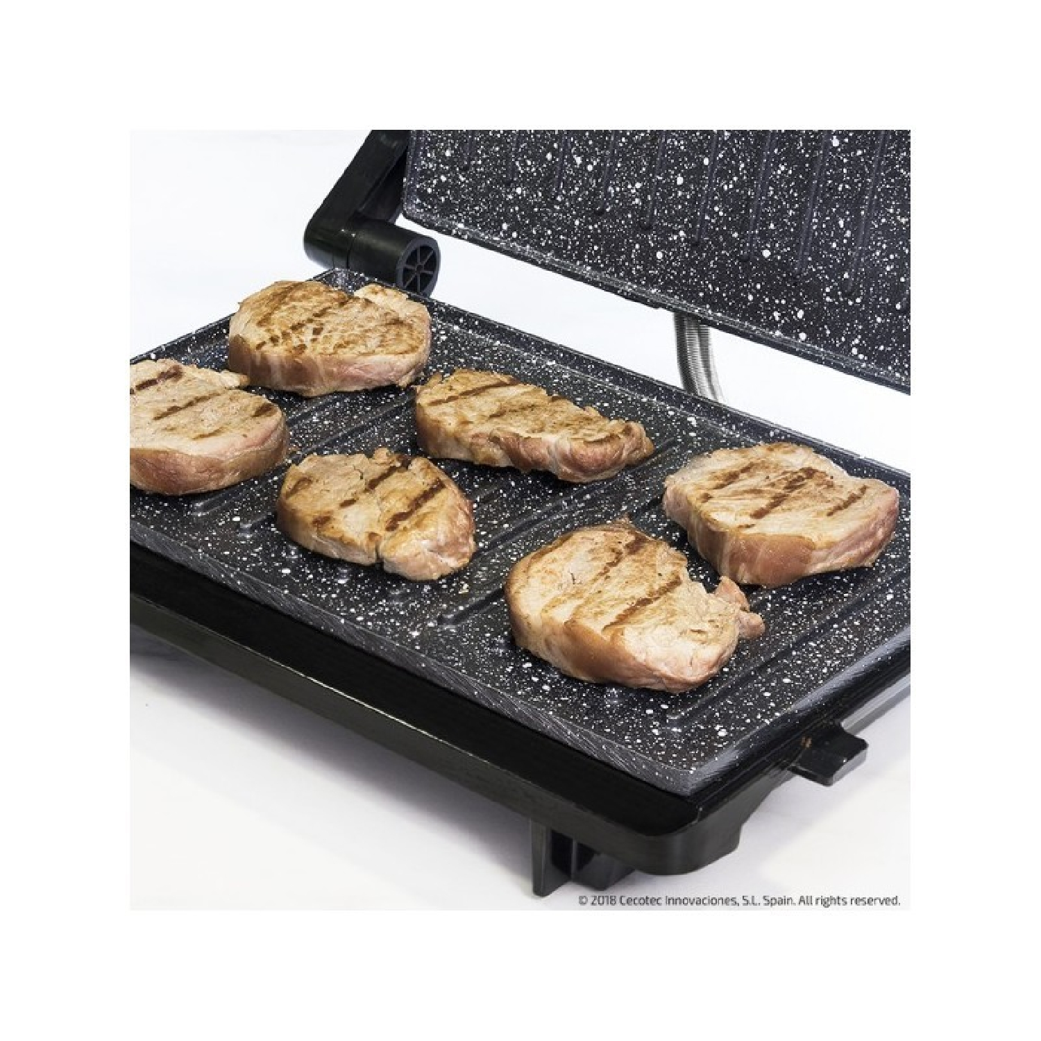 Sechs Steaks werden auf einem schwarzen Grill mit Granit-Optik gegrillt.