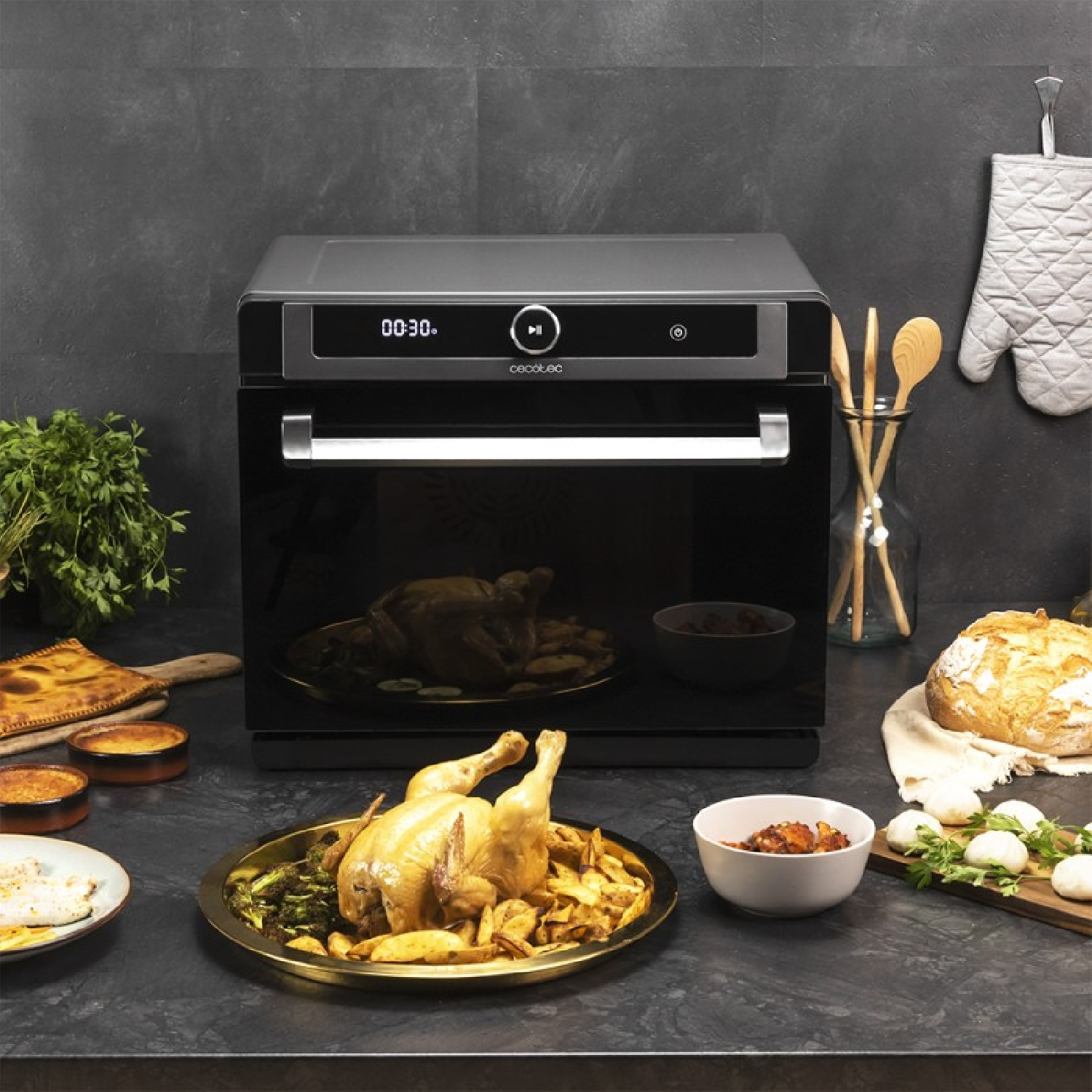 Un horno moderno muestra 00:30. Al lado, pollo asado, pan y guarniciones.