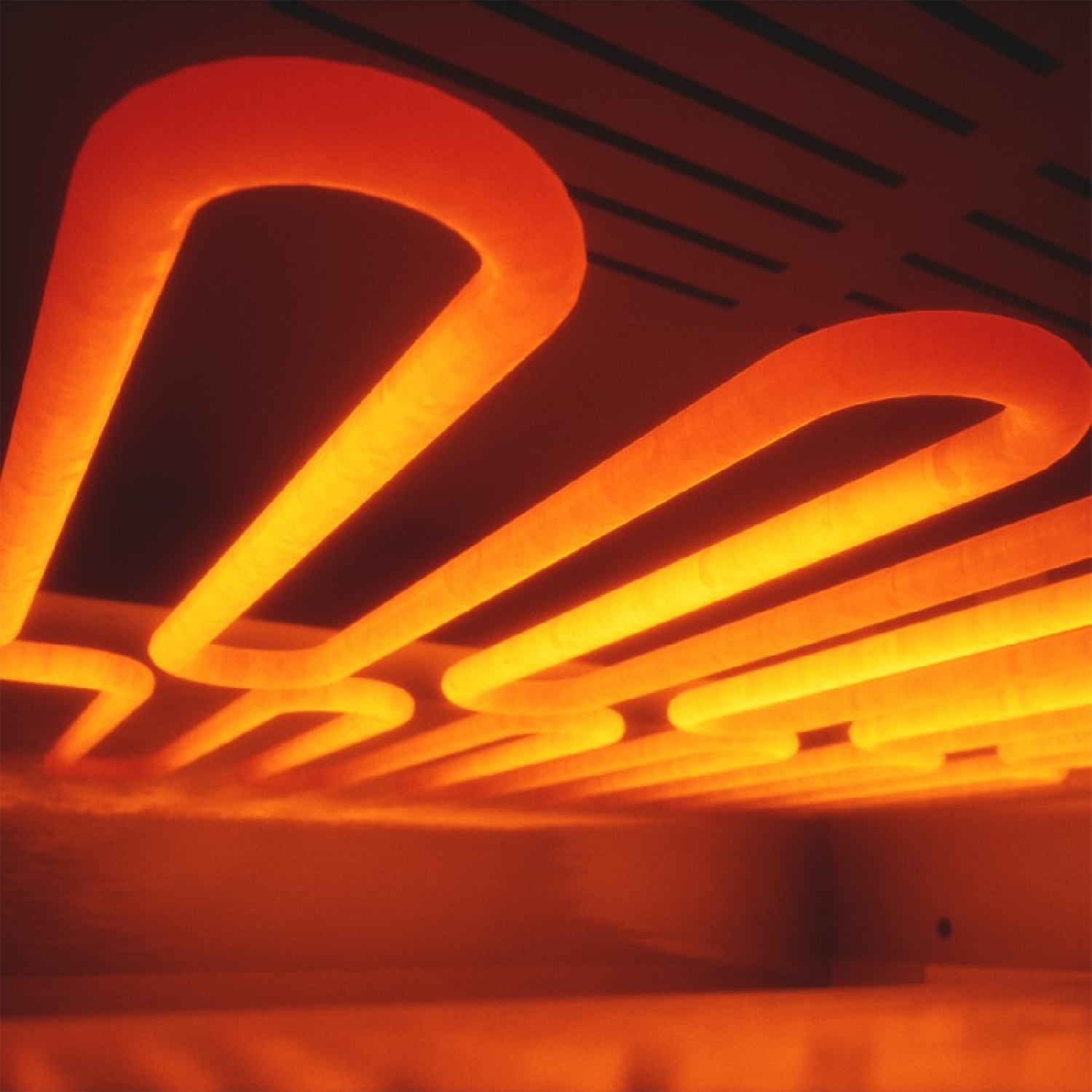 Elementi riscaldanti incandescenti in un forno, che emettono luce arancione.