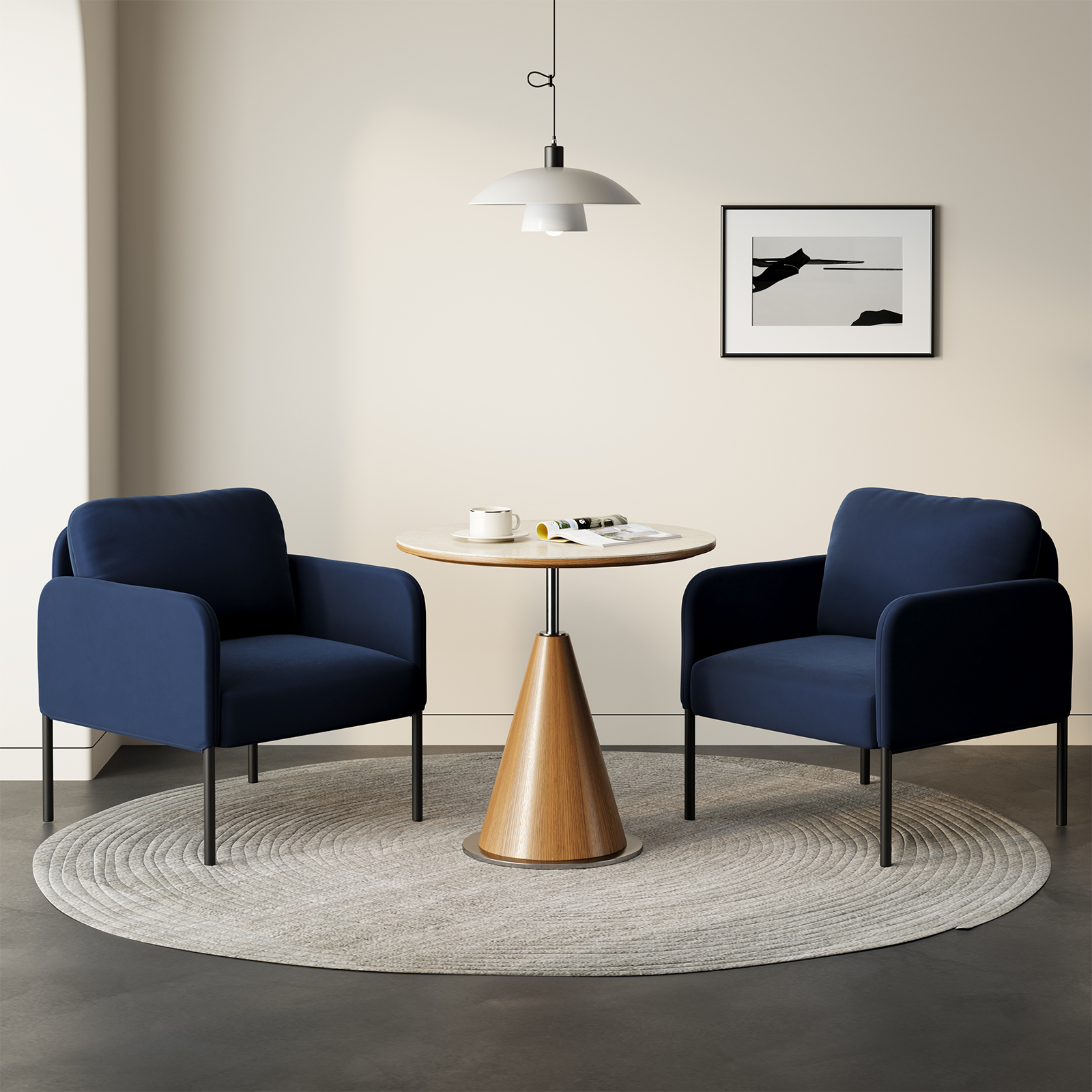 Due poltrone blu navy fiancheggiano un tavolo rotondo con tazza e riviste.