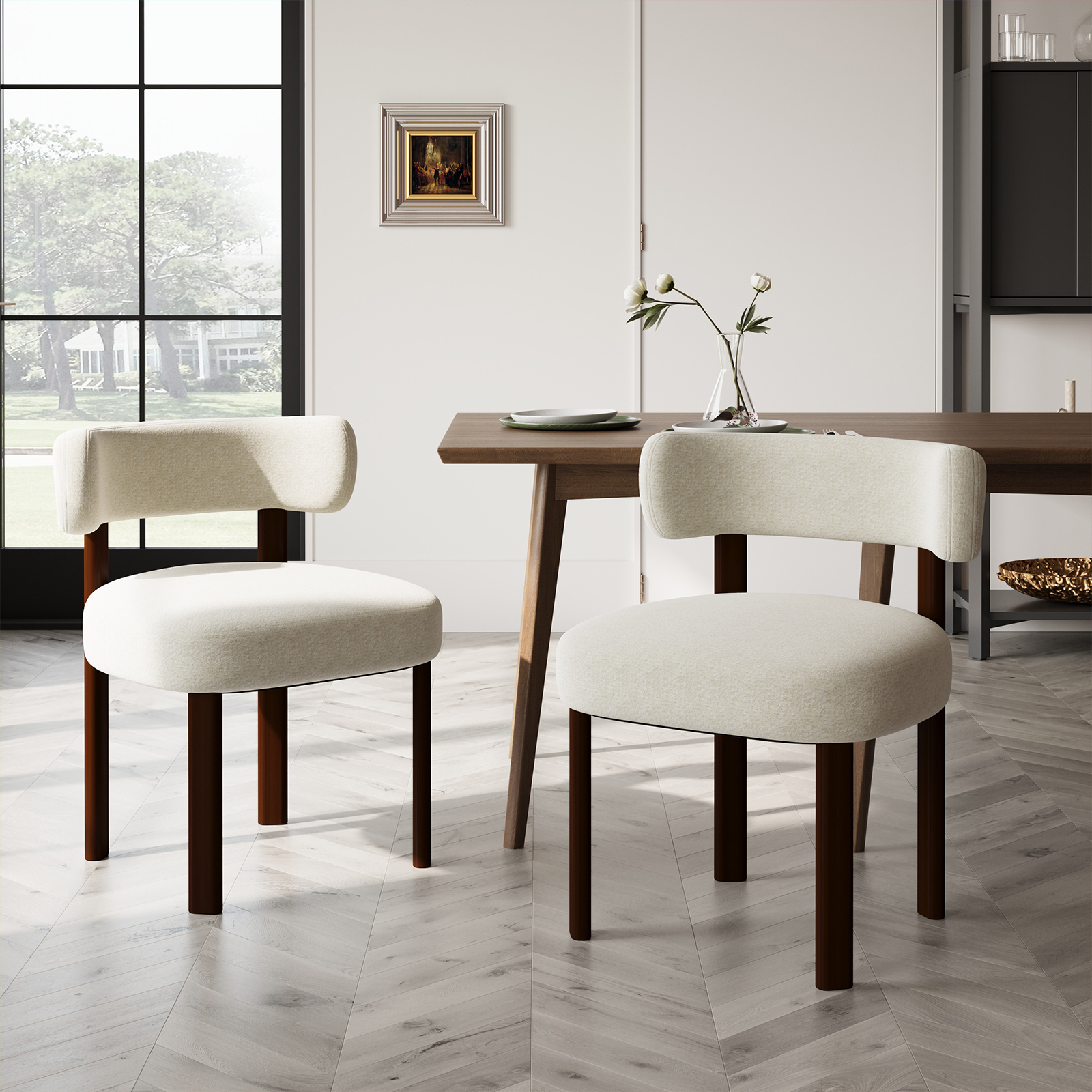 Due sedie color crema davanti a un tavolo di legno in una stanza luminosa.
