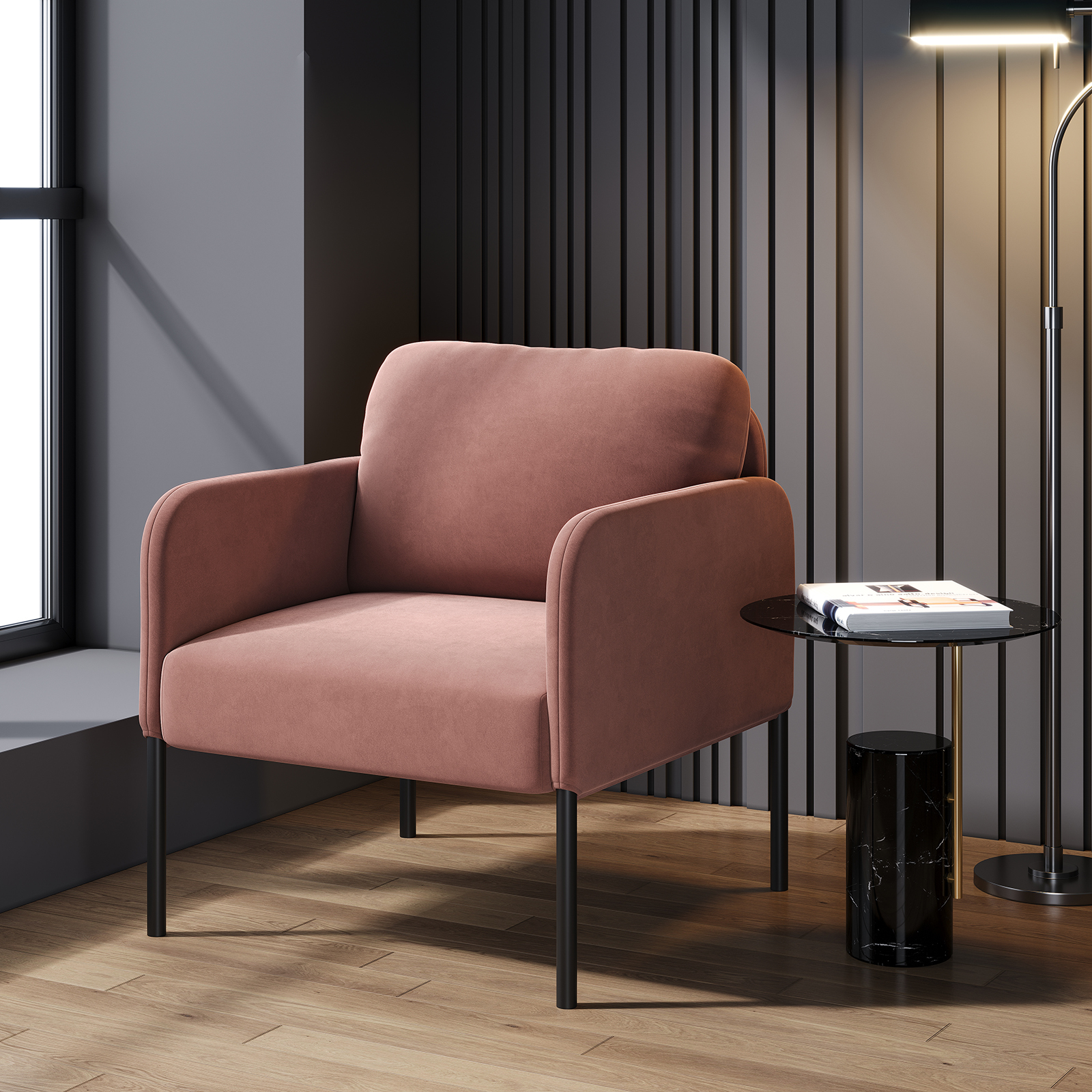 Una poltrona rosa con gambe nere accanto a un tavolino nero con libri e una lampada da terra.
