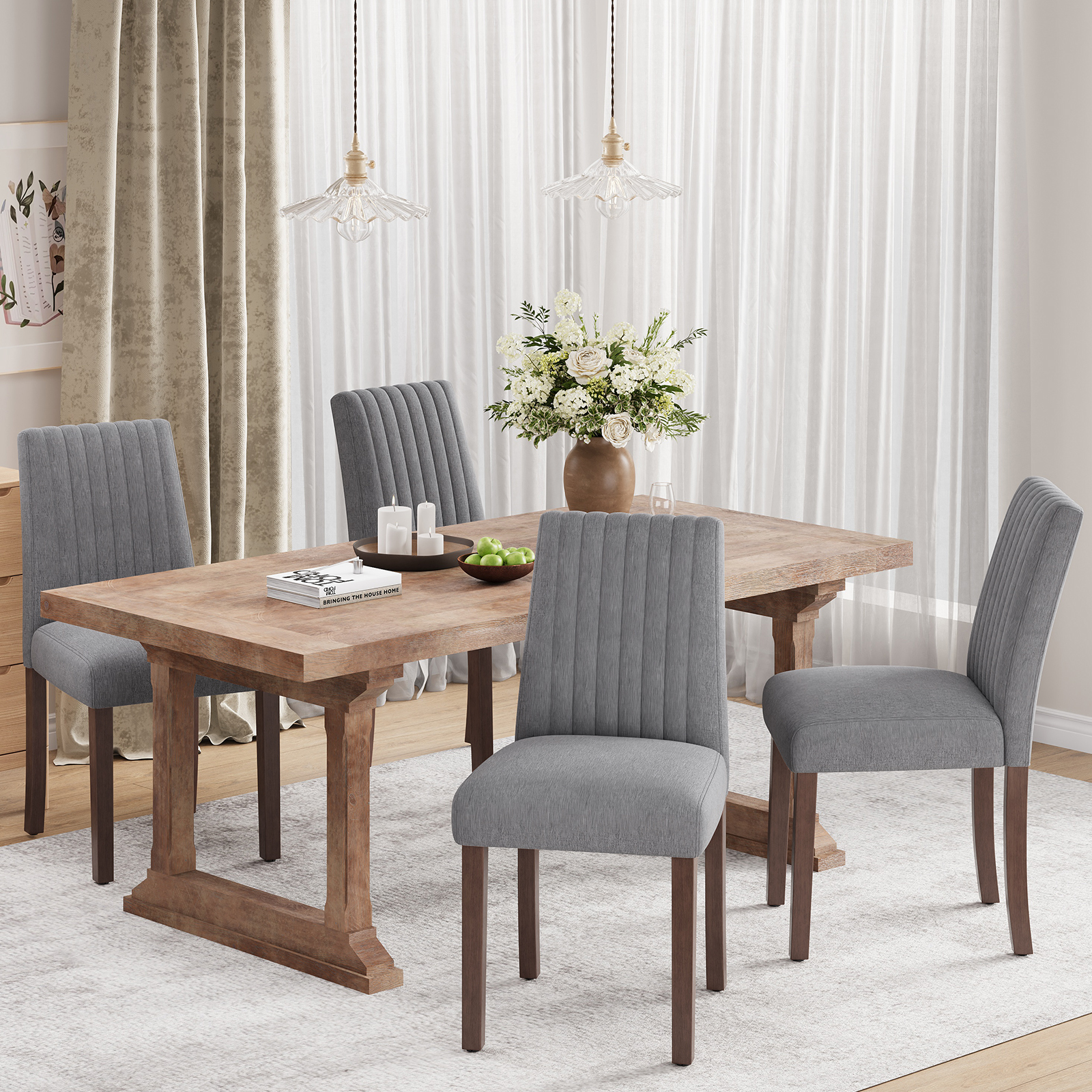 Tavolo in legno con quattro sedie grigie, fiori e candele su tappeto.