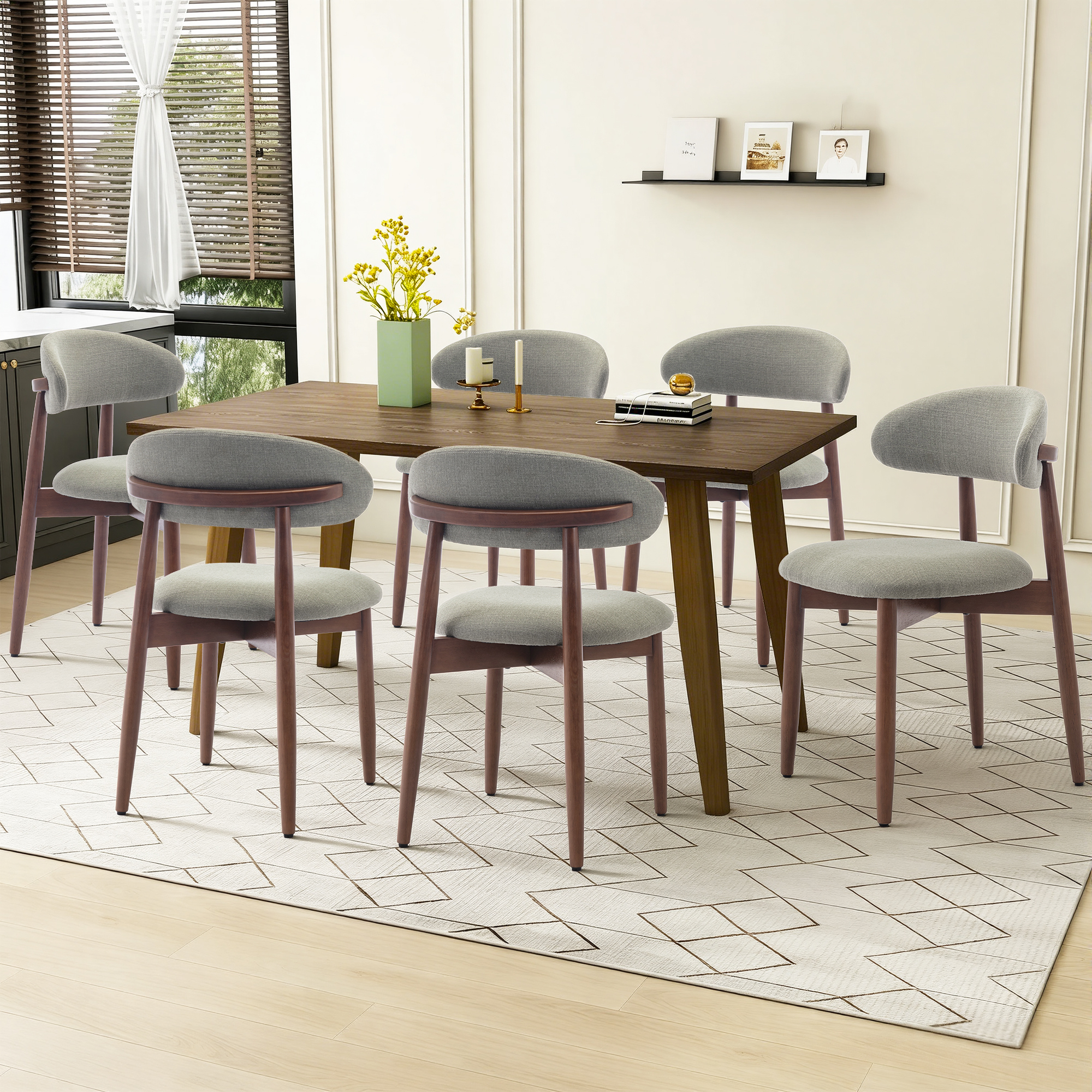 Esszimmer mit Holztisch, grauen Stühlen, Vase mit gelben Blumen und Bildern an der Wand.