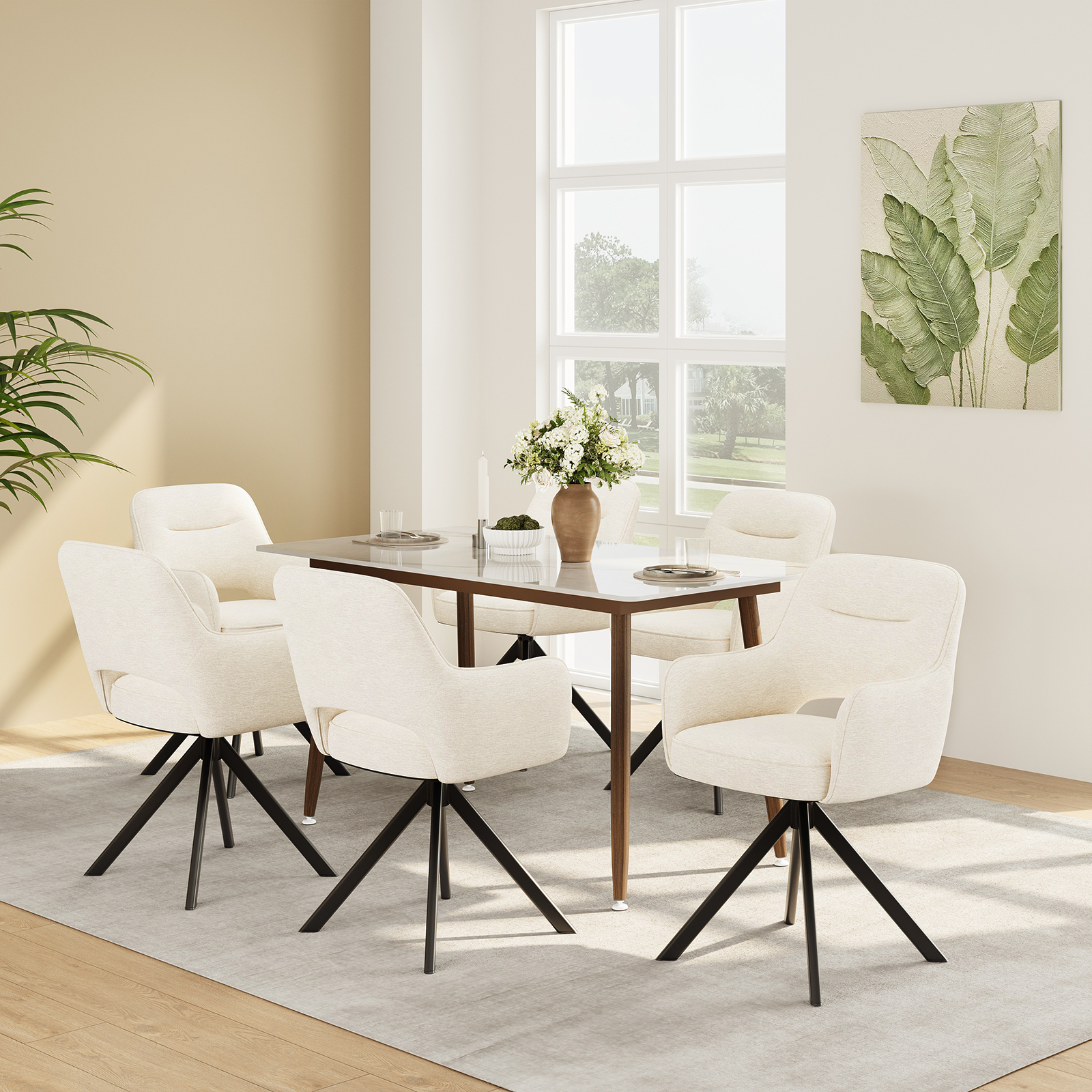 Una sala da pranzo con tavolo, quattro sedie, fiori e un quadro.