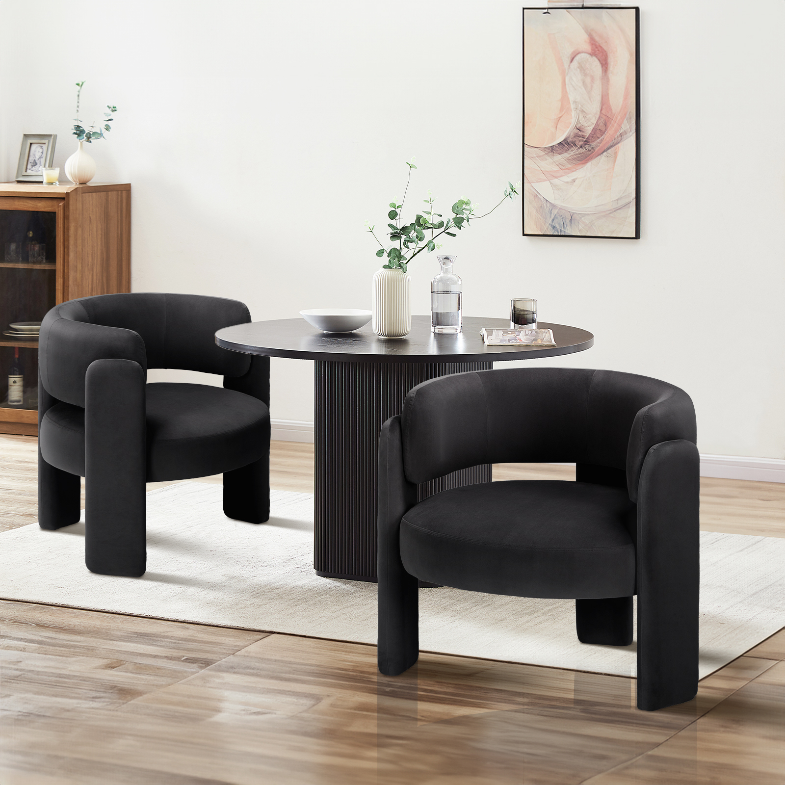 Zwei schwarze Stühle und ein runder Tisch mit Dekoration in einem Esszimmer.