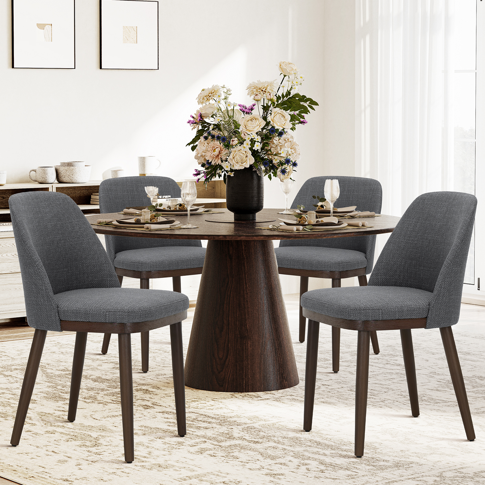 Un tavolo da pranzo rotondo in legno con quattro sedie grigie, adornato di fiori.