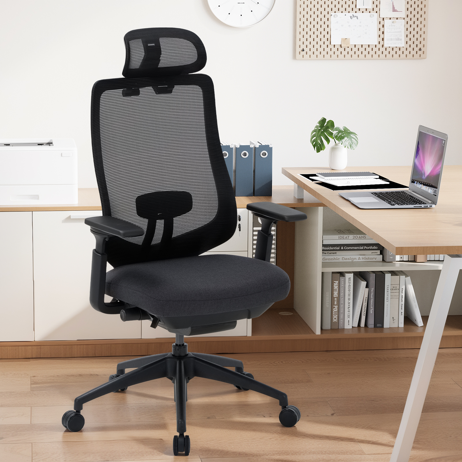 Silla de oficina negra con respaldo de malla y reposacabezas, en un escritorio.