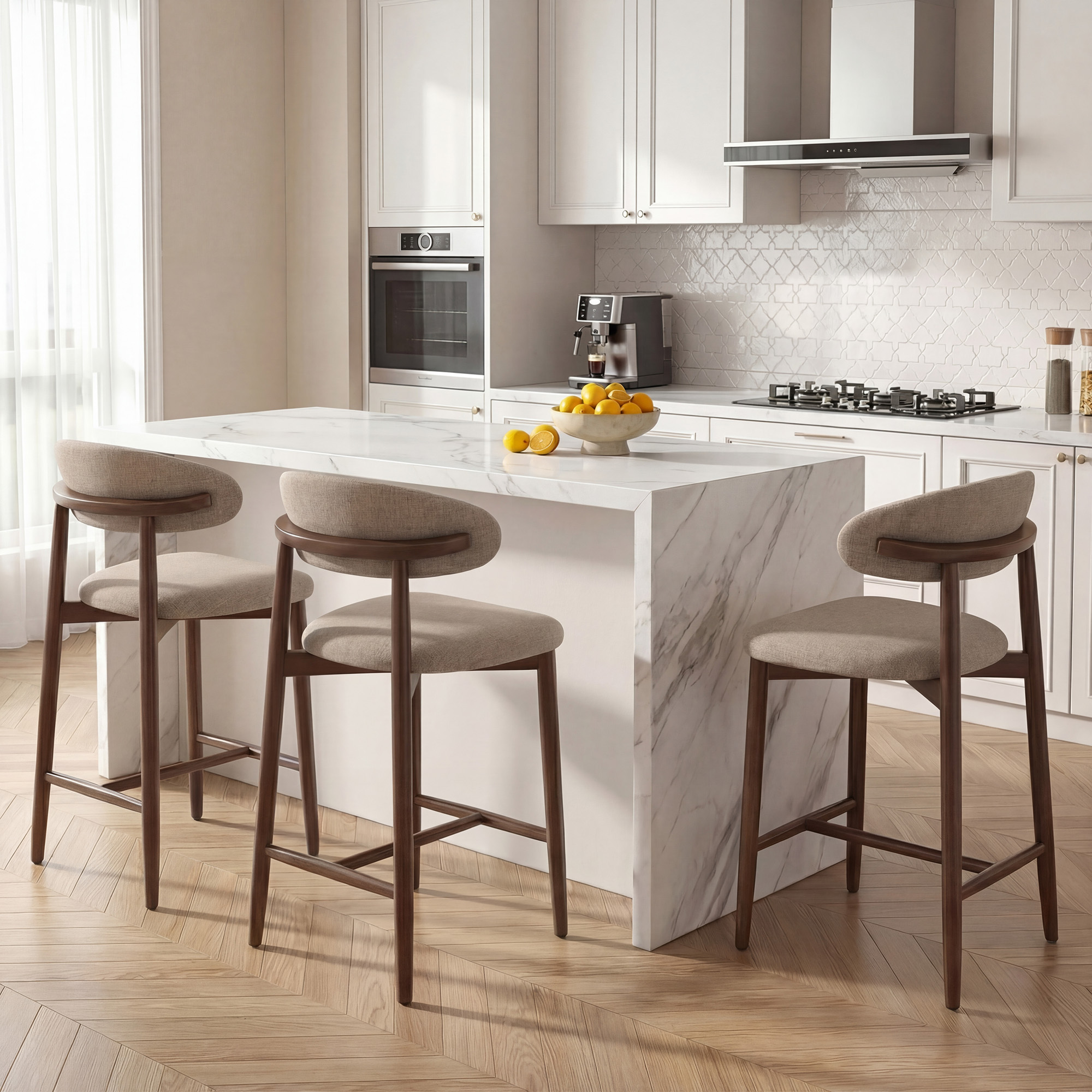 Cucina moderna con isola in marmo, sgabelli, macchina da caffè e ciotola di limoni.