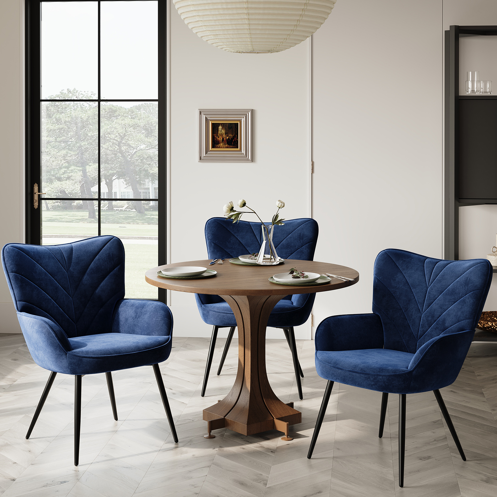 Un tavolo rotondo in legno con quattro sedie in velluto blu in una sala da pranzo.