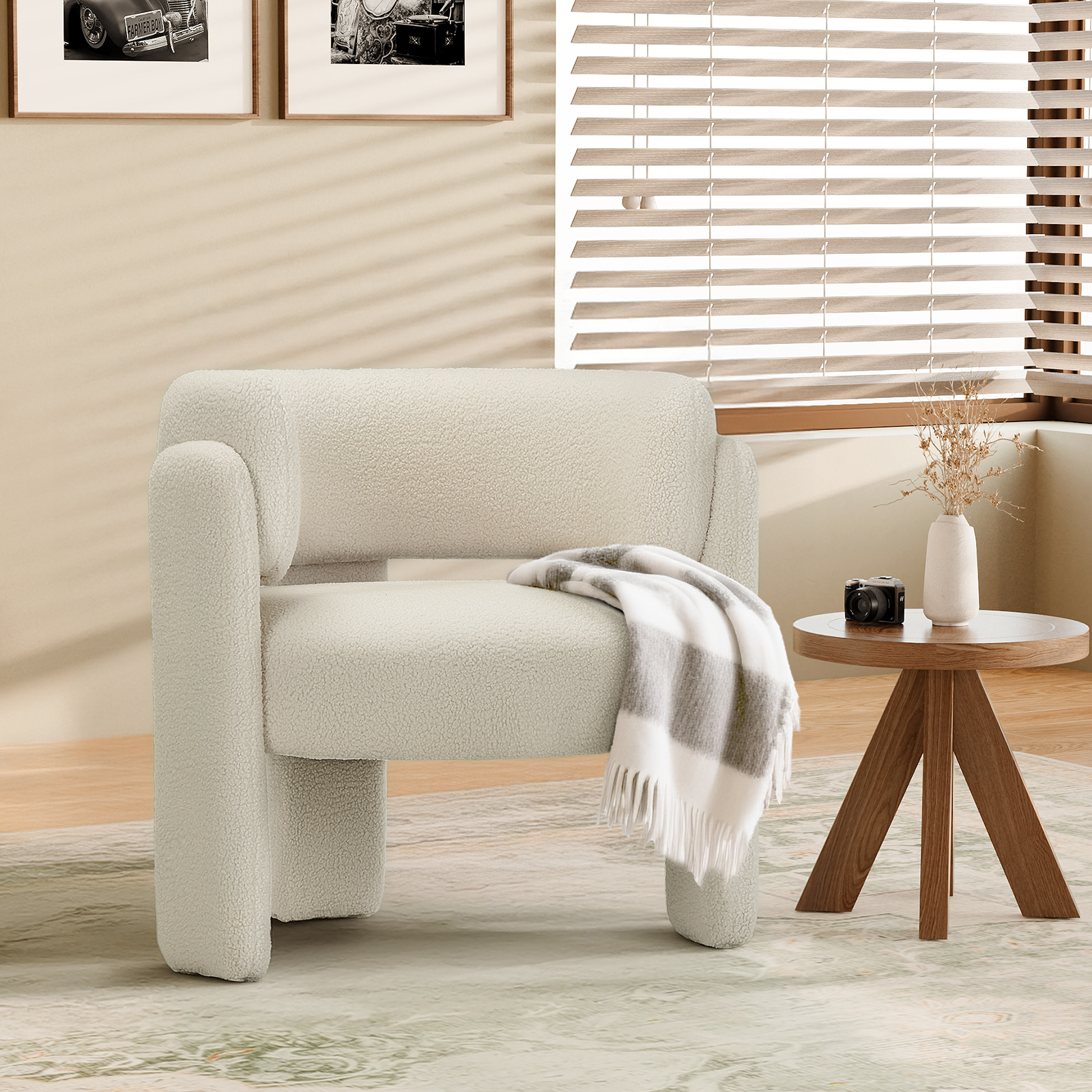 Ein cremefarbener Teddy-Sessel mit Decke, daneben ein Beistelltisch mit Vase und Kamera.
