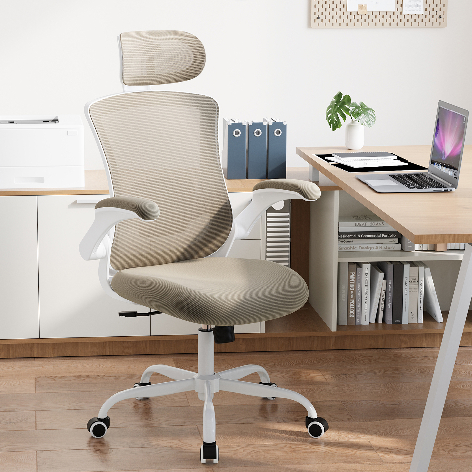 Silla de oficina con respaldo de malla y reposacabezas, portátil, impresora.