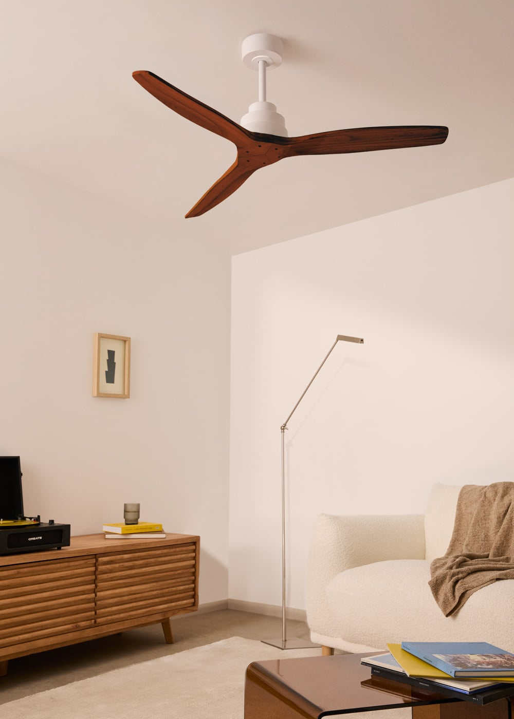 Una sala de estar moderna con ventilador de techo blanco, mueble de madera y sofá.