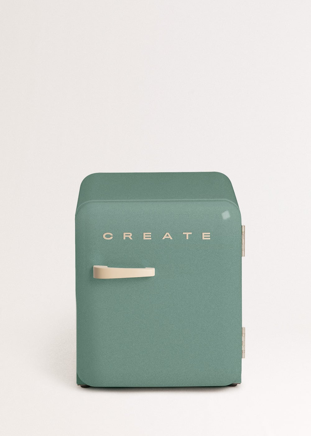 Un pequeño refrigerador verde menta con asa color crema y la palabra CREATE.