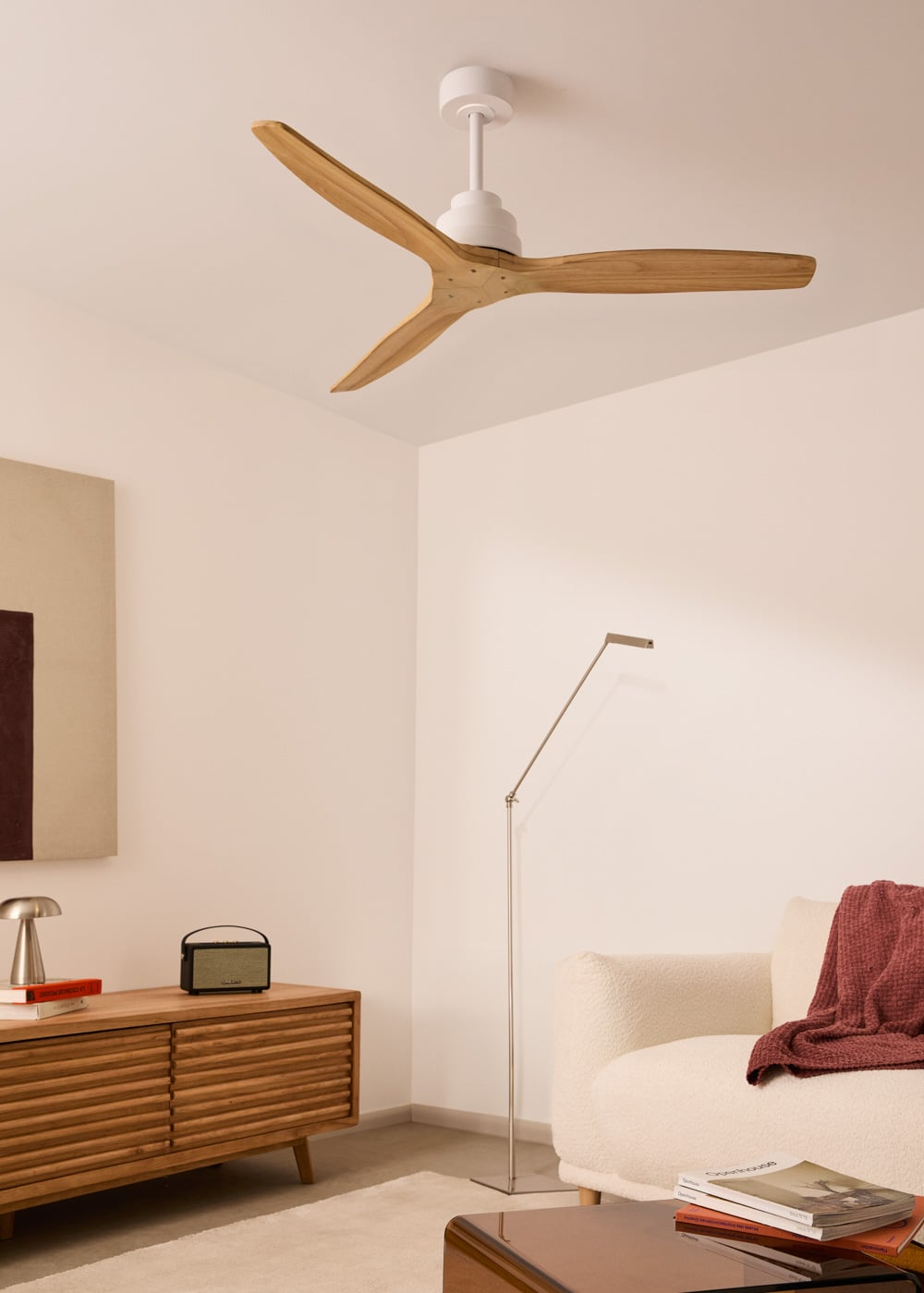 Una sala de estar moderna con ventilador de techo de madera, lámpara de pie y sofá.