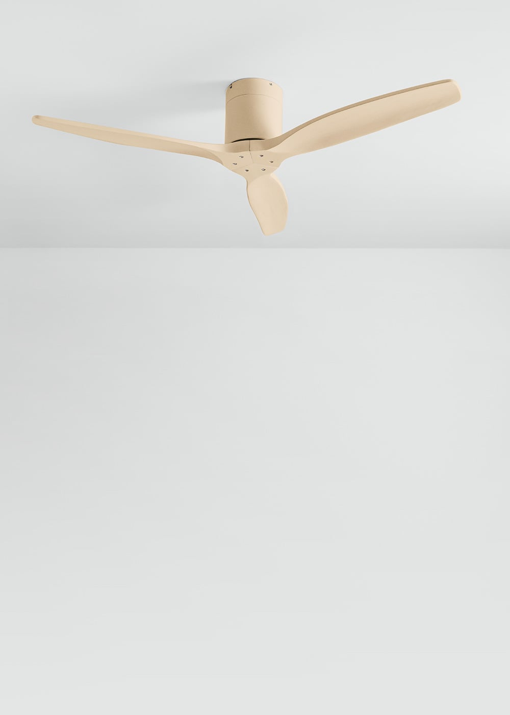 Un ventilador de techo beige de tres aspas está montado en un techo blanco.