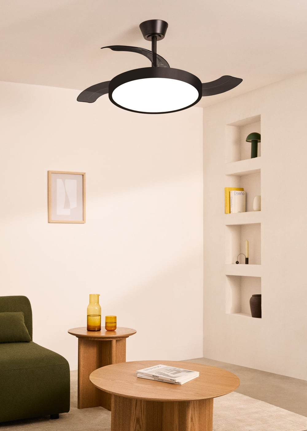 Un ventilador de techo negro con luz sobre una mesa de madera con vasos.
