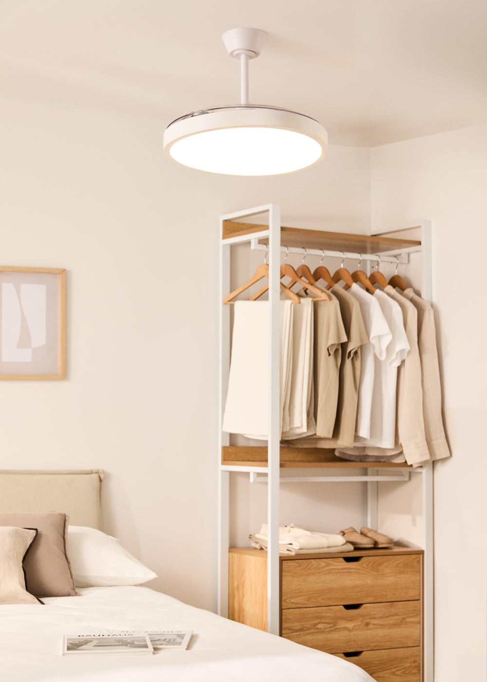 Un dormitorio con perchero, cama y lámpara de techo.