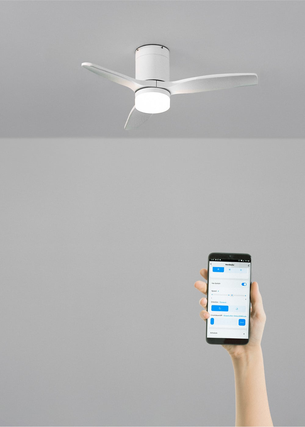 Un ventilador de techo blanco con luz es controlado por una mano que sostiene un teléfono con una aplicación.