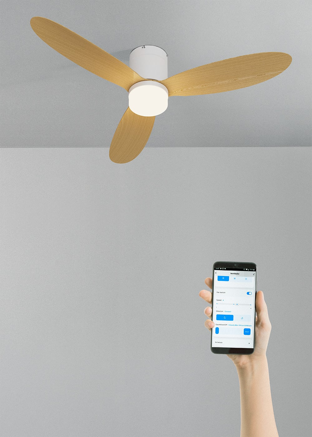 Un ventilador de techo con tres aspas de madera y un smartphone con una app de control.