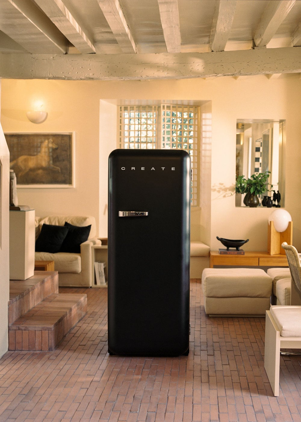 Un refrigerador negro con la inscripción CREATE se alza en una sala luminosa con vigas de madera.