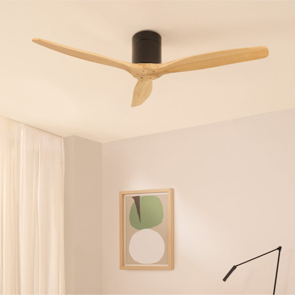 Un ventilador de techo moderno con aspas de madera cuelga sobre una obra de arte minimalista en una pared blanca.