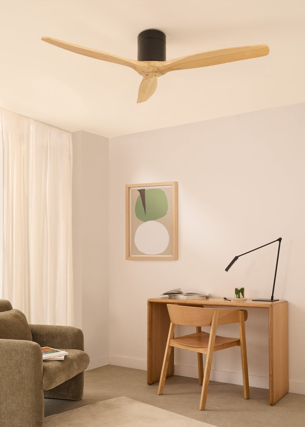 Un espacio de trabajo con escritorio, silla, lámpara y obra de arte.