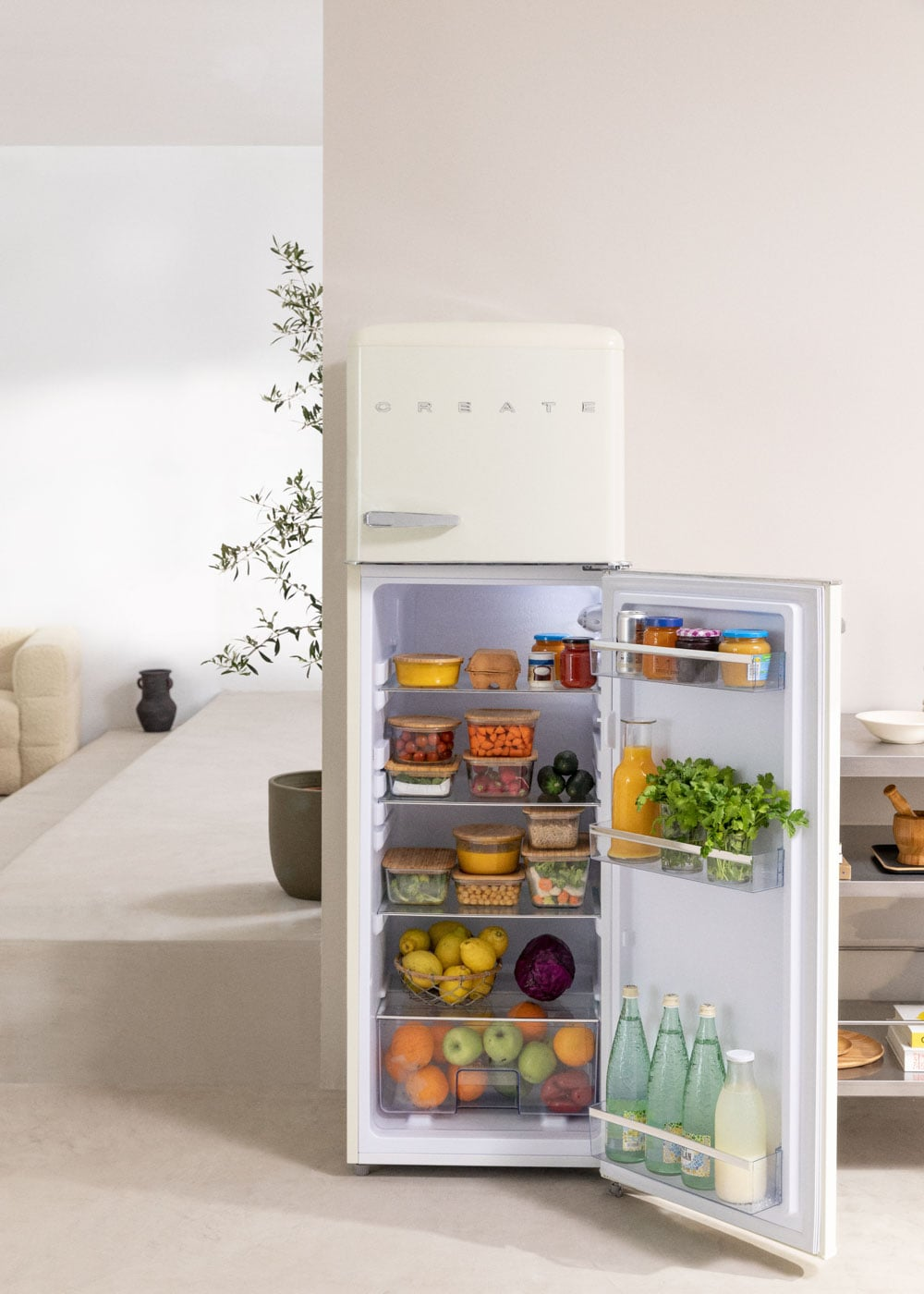 Un refrigerador abierto color crema lleno de comida, frutas y verduras.