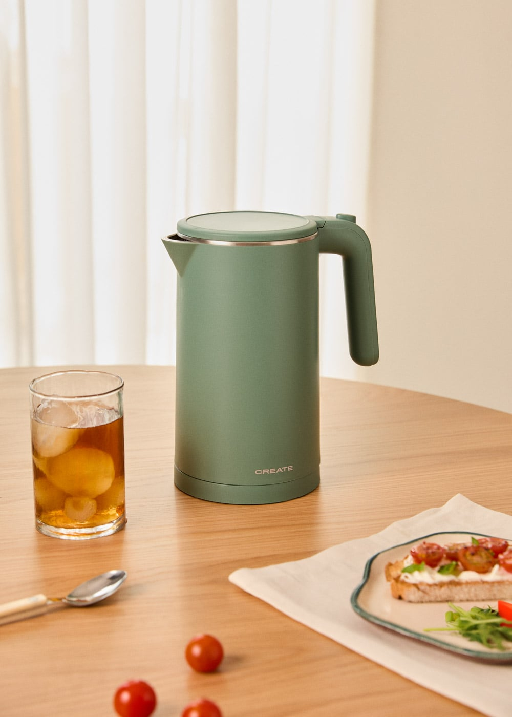 Tetera verde con té helado y tostada en mesa de madera.